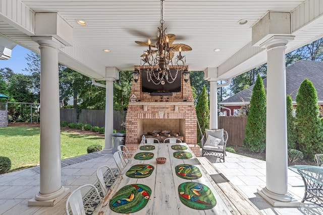 view of patio / terrace featuring fence and an outdoor brick fireplace