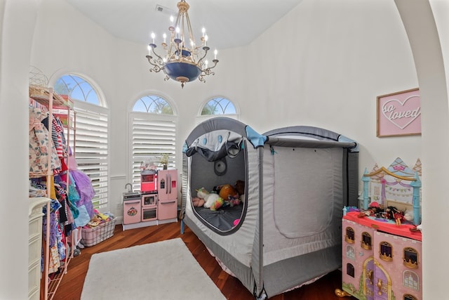 bedroom featuring a notable chandelier and dark hardwood / wood-style flooring