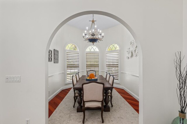 dining space with hardwood / wood-style flooring and an inviting chandelier