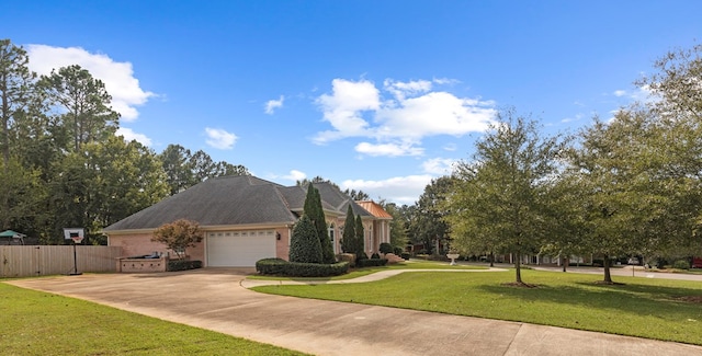 view of front of property featuring concrete driveway, a front lawn, an attached garage, fence, and brick siding