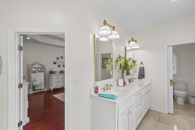 bathroom with toilet, hardwood / wood-style flooring, and vanity