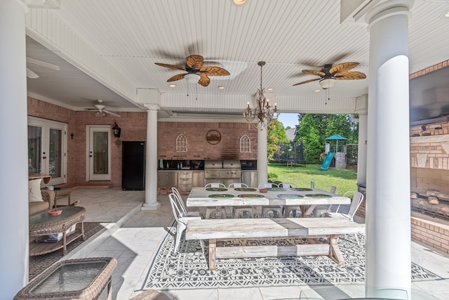 view of patio / terrace with an outdoor kitchen, a ceiling fan, a playground, outdoor dining space, and a trampoline