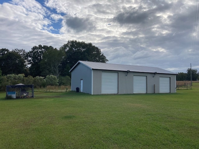 view of outbuilding featuring a garage and a lawn