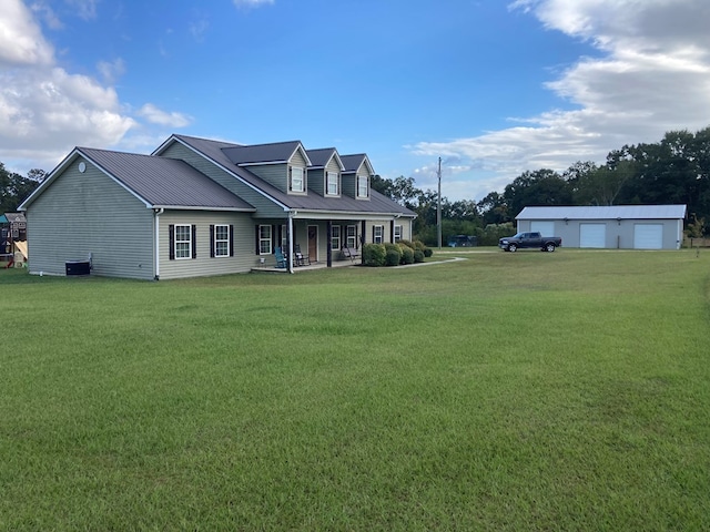 back of property with covered porch, a garage, an outdoor structure, and a yard