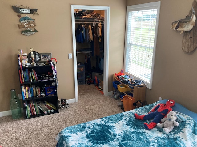 carpeted bedroom featuring a spacious closet and a closet