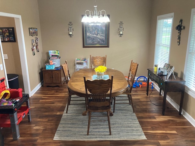 dining room with dark hardwood / wood-style flooring and a notable chandelier