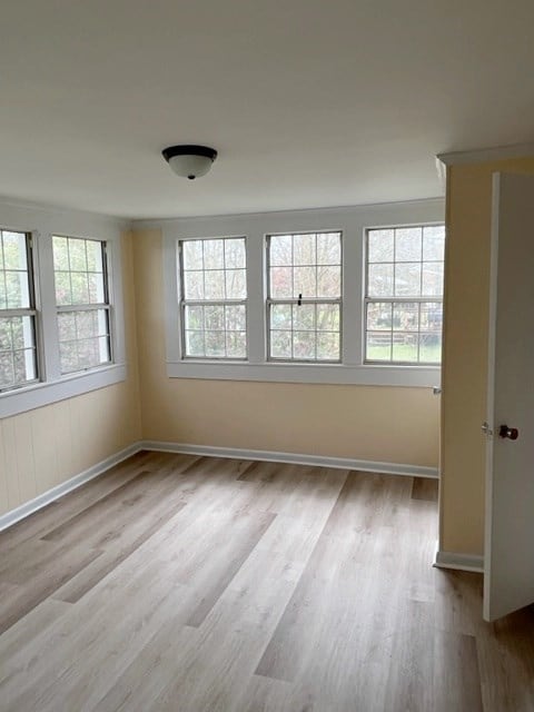 empty room with baseboards and wood finished floors