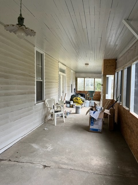 unfurnished sunroom featuring wood ceiling and ceiling fan