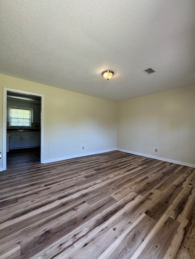 629 Coe Dairy Rd, Dothan, AL 36301 - spare room with dark wood-type flooring, a sink, baseboards, and a textured ceiling