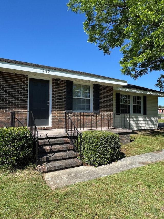 629 Coe Dairy Rd, Dothan, AL 36301 - view of front of home featuring brick siding, covered porch, and a front yard