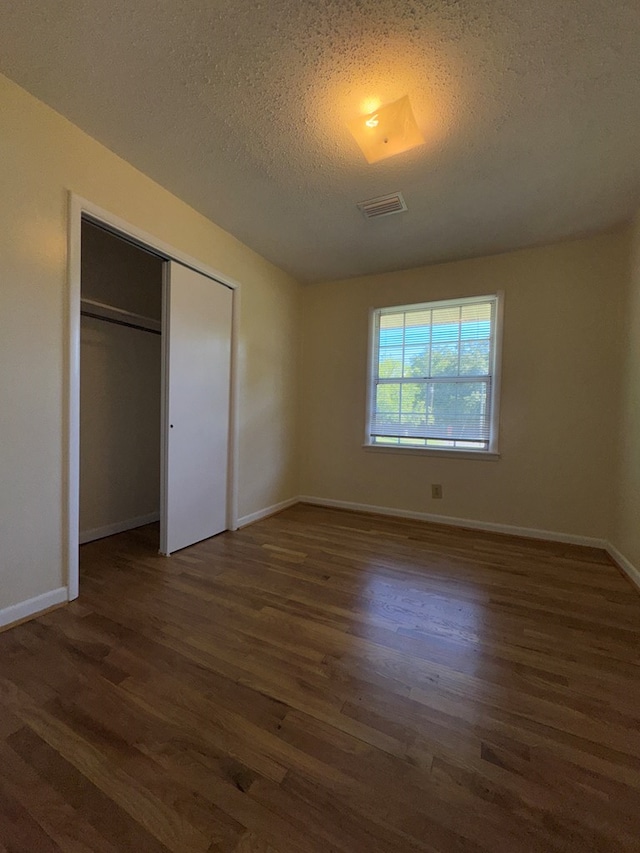 629 Coe Dairy Rd, Dothan, AL 36301 - unfurnished bedroom with wood finished floors, a closet, a textured ceiling, and baseboards