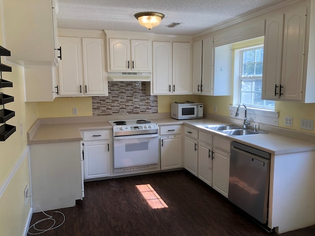 kitchen featuring white appliances, light countertops, under cabinet range hood, white cabinetry, and a sink