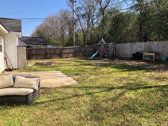 view of yard with a storage shed, a patio, a playground, and a fenced backyard