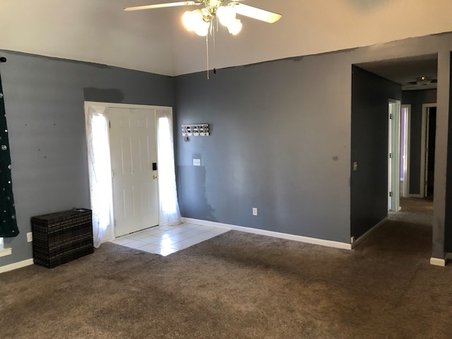 carpeted entryway featuring ceiling fan, tile patterned flooring, lofted ceiling, and baseboards