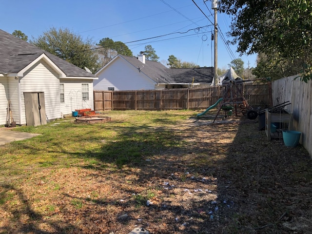 view of yard featuring a playground and a fenced backyard