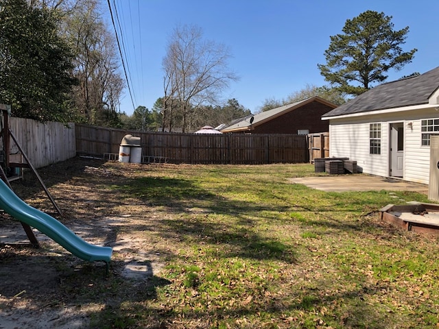 view of yard with a playground, a patio area, and a fenced backyard