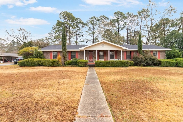 ranch-style home featuring a front lawn and covered porch