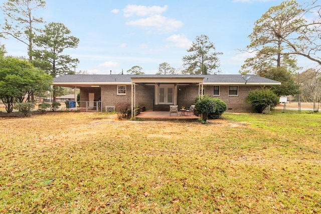 back of house with a lawn, a patio, and french doors