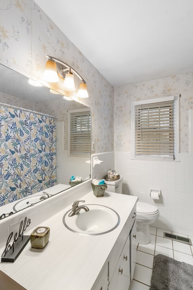 bathroom with tile patterned floors, curtained shower, vanity, and toilet