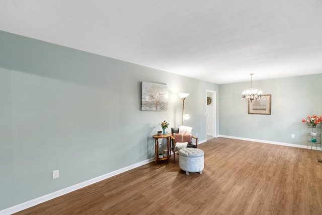 living area with wood-type flooring and an inviting chandelier