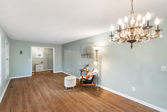 unfurnished room featuring wood-type flooring and an inviting chandelier