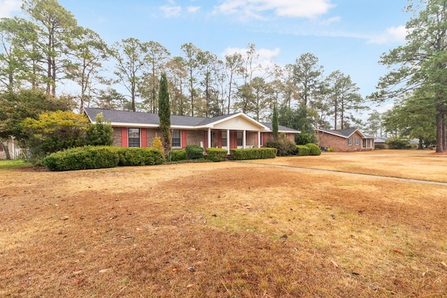 ranch-style home with a porch and a front yard