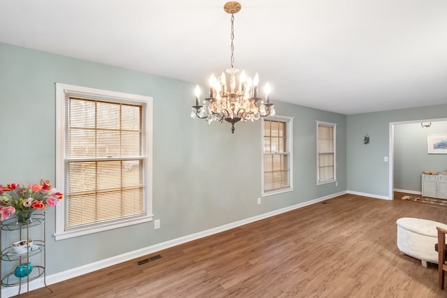 unfurnished room featuring hardwood / wood-style floors and a chandelier