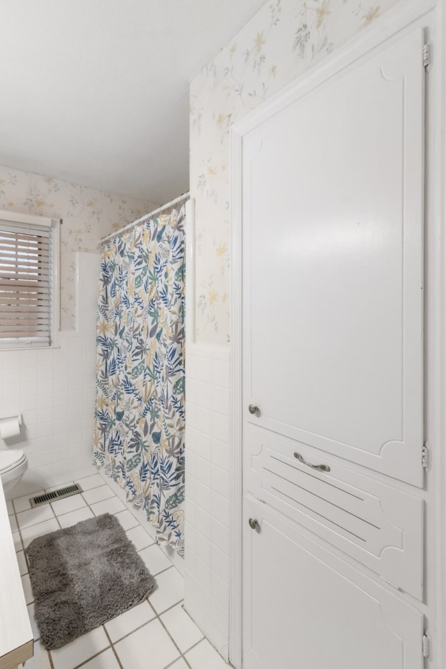 bathroom featuring tile patterned floors and tile walls