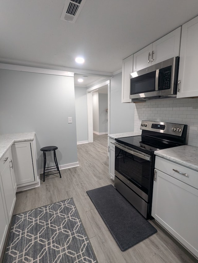 kitchen featuring light countertops, appliances with stainless steel finishes, and decorative backsplash