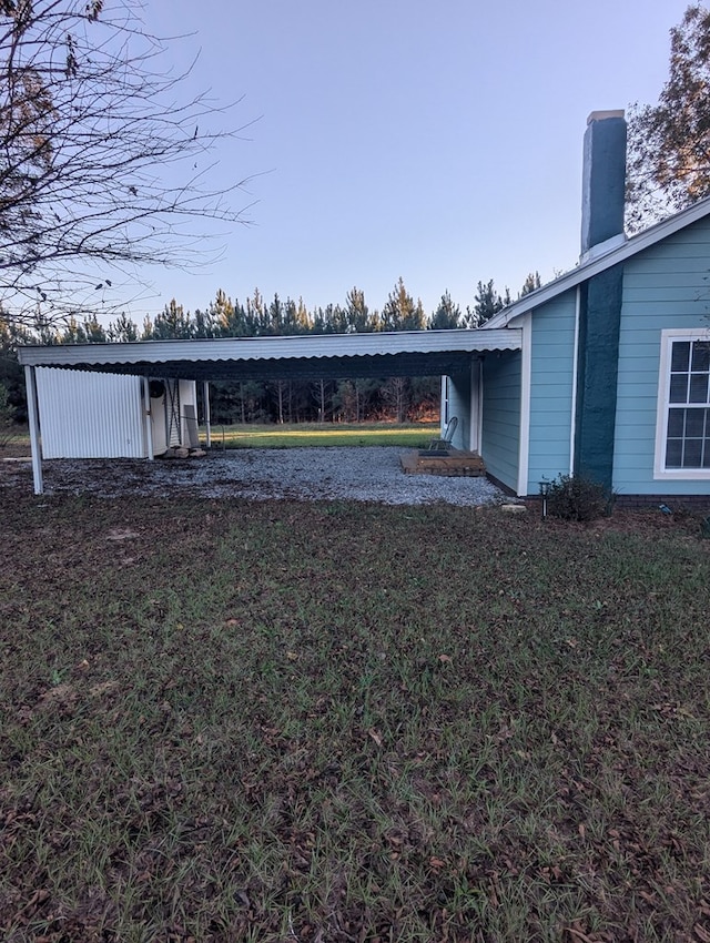 view of yard with driveway and a carport