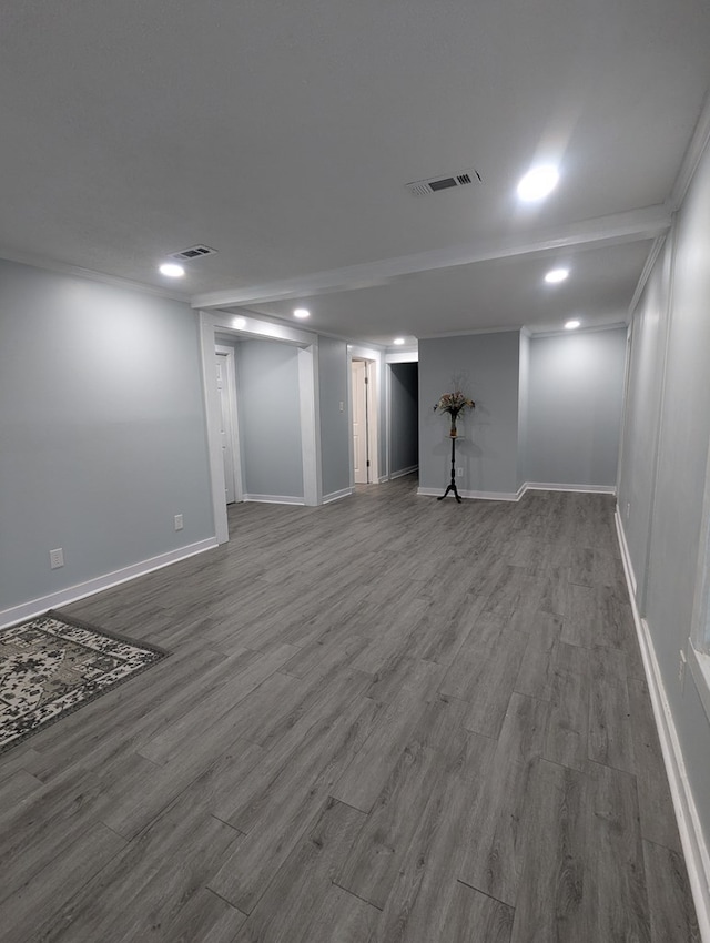 finished below grade area with baseboards, visible vents, and wood finished floors