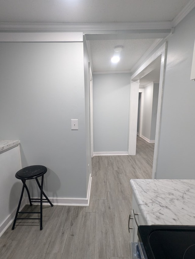 interior space featuring ornamental molding, wood finished floors, and baseboards