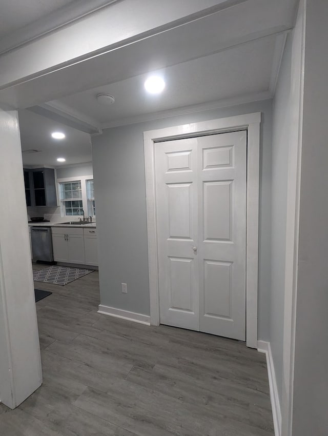 interior space featuring crown molding, baseboards, and wood finished floors