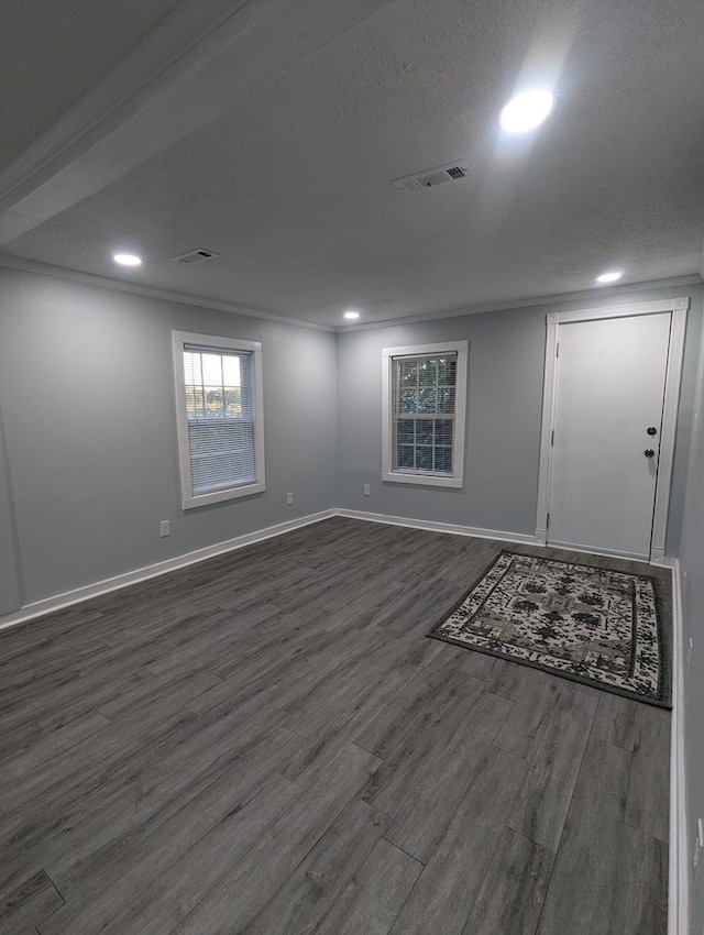 entrance foyer featuring a textured ceiling, dark wood-style flooring, visible vents, and baseboards