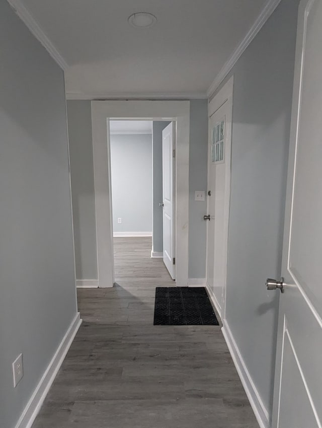 hall with baseboards, crown molding, and wood finished floors