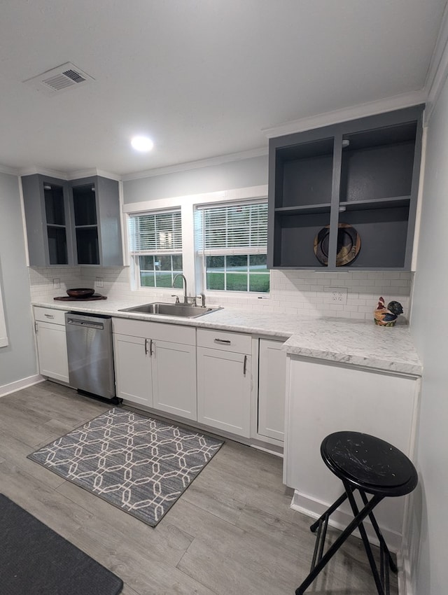 kitchen featuring visible vents, stainless steel dishwasher, light wood-style floors, open shelves, and a sink