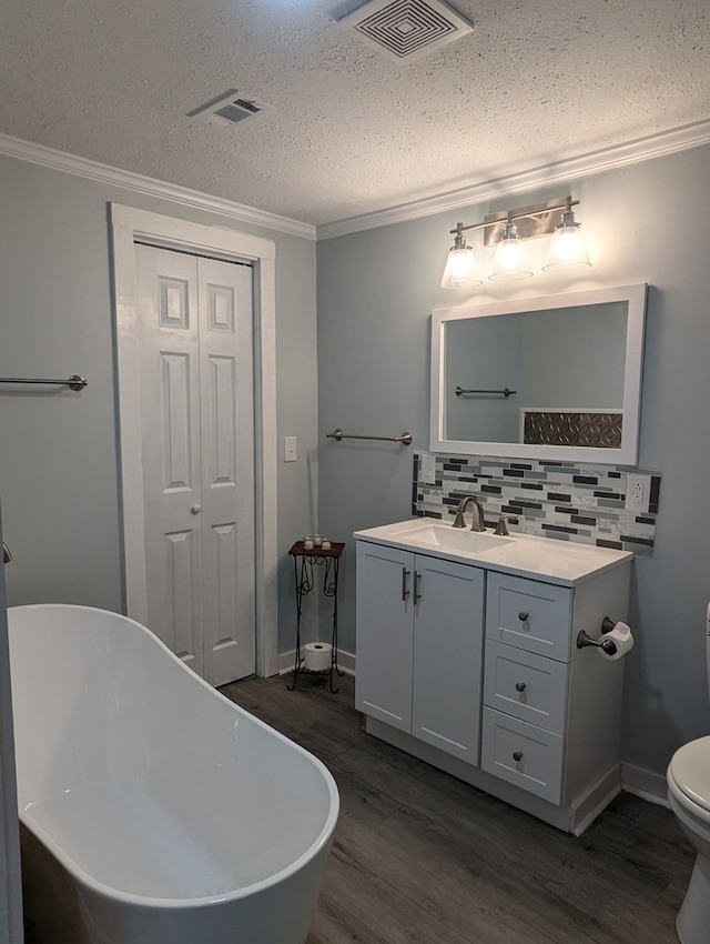 bathroom featuring ornamental molding, visible vents, toilet, and wood finished floors