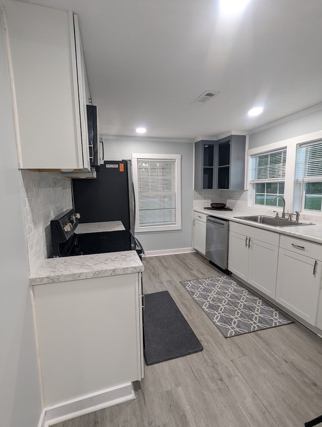 kitchen with appliances with stainless steel finishes, visible vents, a sink, and decorative backsplash