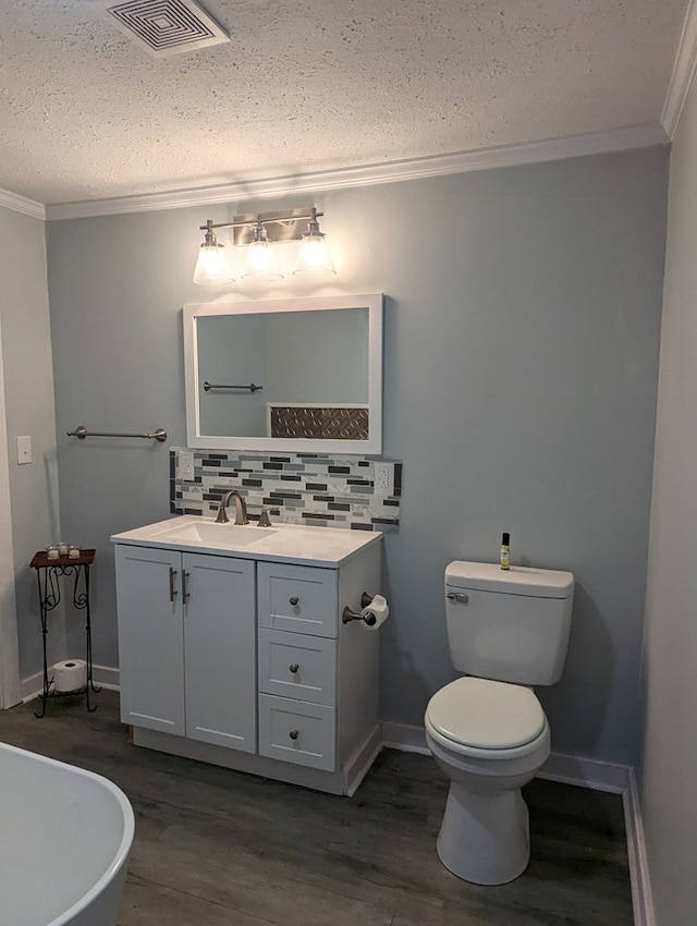 bathroom with vanity, visible vents, crown molding, and wood finished floors