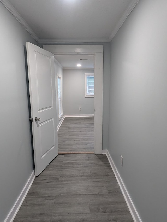 hallway with baseboards, dark wood finished floors, and crown molding