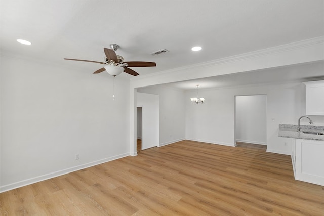 unfurnished living room with visible vents, baseboards, light wood-style floors, and ornamental molding