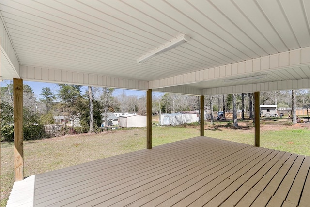 wooden terrace with a lawn and an outdoor structure