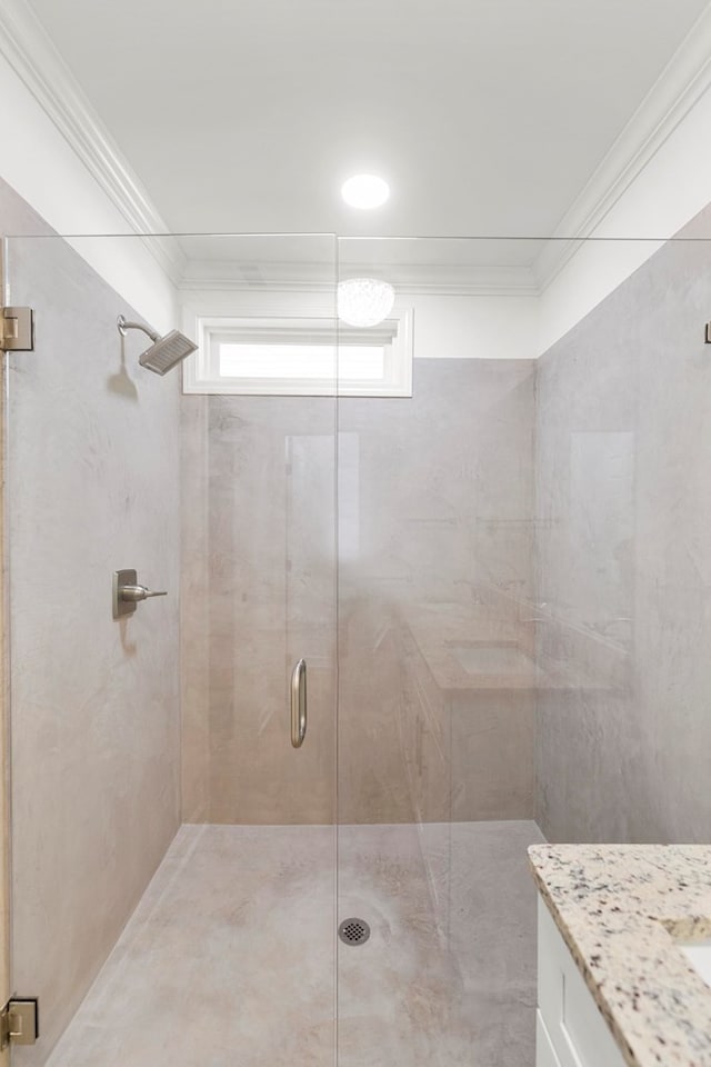 full bathroom with vanity, a shower stall, and crown molding