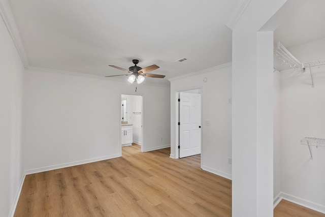 unfurnished room featuring baseboards, light wood-style floors, visible vents, and ornamental molding