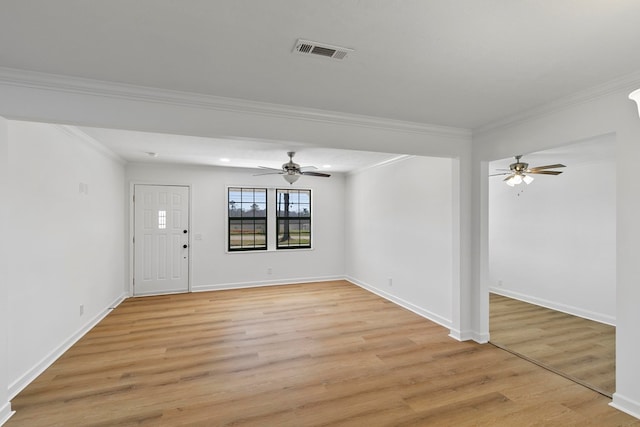 foyer featuring visible vents, crown molding, ceiling fan, baseboards, and light wood-style floors