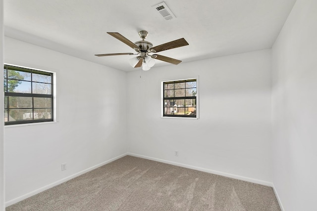 spare room with visible vents, carpet flooring, plenty of natural light, and baseboards