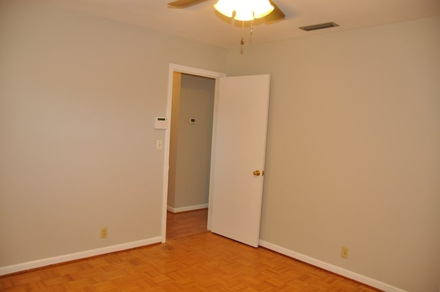 spare room with ceiling fan and light parquet flooring