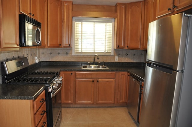 kitchen featuring decorative backsplash, sink, light tile patterned floors, and stainless steel appliances