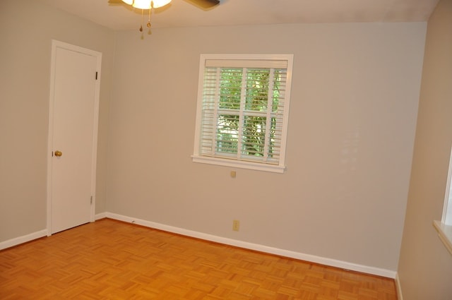 empty room with ceiling fan and light parquet flooring