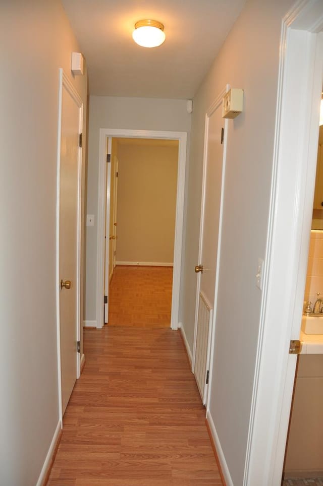 hall with light hardwood / wood-style floors and sink